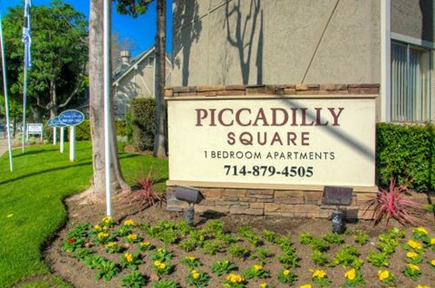 a sign for piccadilly square in front of a building